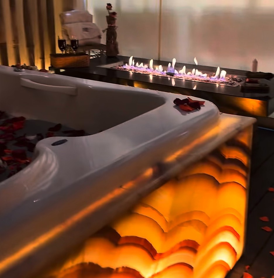 Jacuzzi de ónix encendido con pétalos y velas en ISIS Spa